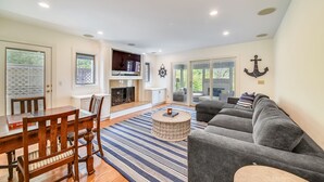 A spacious living room with a dining area, a fireplace, and a large gray sofa. - 5 ⭐️ property! Private pool!!SHORT walk to beach!! ❤️ of Sea Pines. Sleeps 12 (Hilton Head Island)