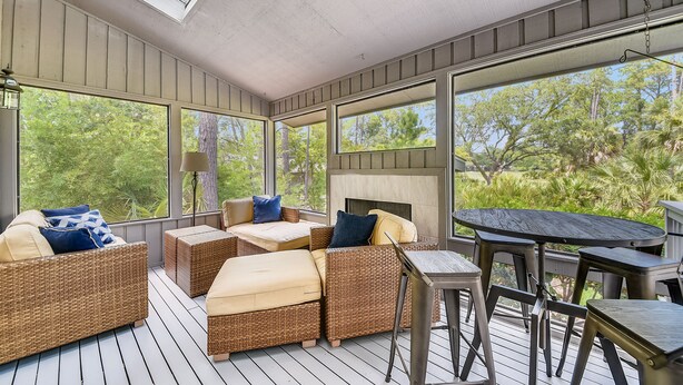A covered outdoor seating area with wicker furniture, a table, and a fireplace. - 5 ⭐️ property! Private pool!!SHORT walk to beach!! ❤️ of Sea Pines. Sleeps 12 (Hilton Head Island)