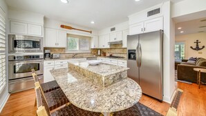 A modern kitchen with white cabinetry, stainless steel appliances, and a granite countertop island. - 5 ⭐️ property! Private pool!!SHORT walk to beach!! ❤️ of Sea Pines. Sleeps 12 (Hilton Head Island)