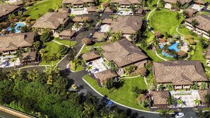 An aerial view of a resort with multiple bungalow-style buildings, a central pool area, and well-maintained landscaping. - KLVR welcomes you to Luana Villa 13B, Oceanfront Resort, short walk to the beach (Lahaina)