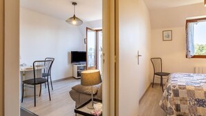 Une chambre à coucher moderne avec un lit, un bureau et un téléviseur.