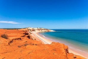 Un paysage désertique avec une plage et un ciel bleu clair.