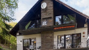 A two-story building with a stone facade, multiple balconies, and a paved courtyard. - Eifelnatur (Haus 1) by Interhome (Immerath)