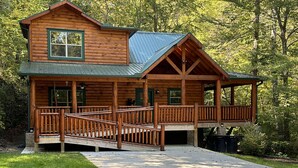 A log cabin with a porch, a covered deck, and a stone fireplace. - Papa Bear’s Retreat, Cedar Falls, 2 BD, 3 BA, Queen Bunk Bed in loft, Fireplaces (Sevierville)