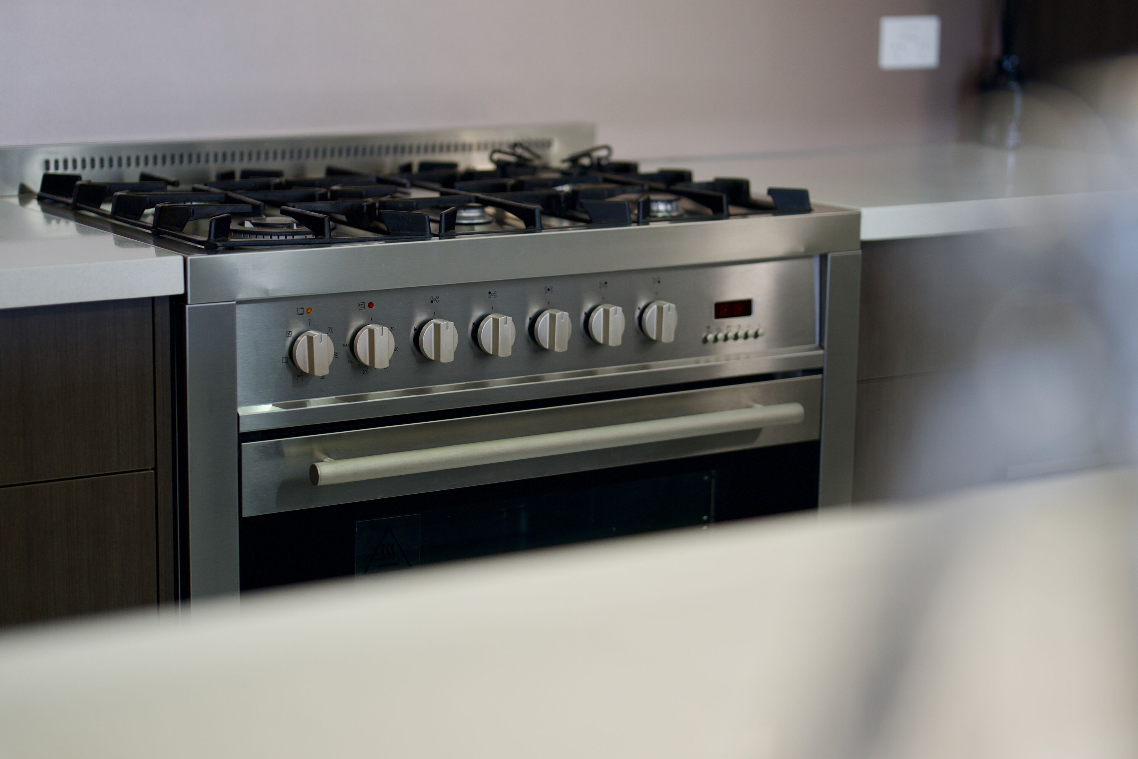 Une cuisine équipée d’un plan de travail, d’une cuisinière à gaz et d’un four, le tout en acier inoxydable.