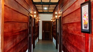 A hallway with wooden walls and a tiled floor, leading to a door at the end. - The Azure - M'Pai Bay (Koh Rong Sanloem)