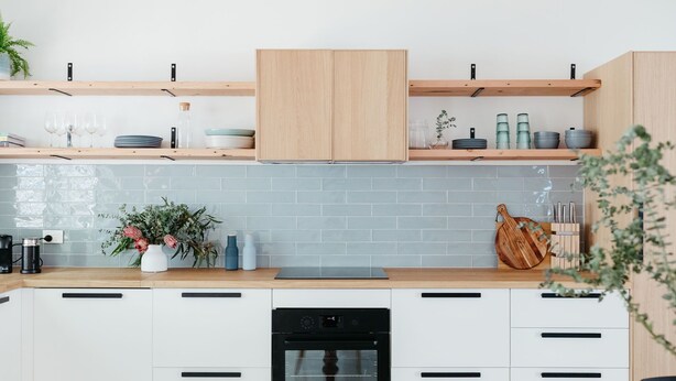 A modern kitchen with white cabinets, a wooden countertop, and a built-in oven. - Anchor in Avoca Beach - enjoy your 4 bedroom coastal getaway (Avoca Beach)