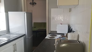 A compact kitchen with a refrigerator, stove, and toaster. - Gateshead's Amethyst 3 Bedroom Apt, Sleeps 6 Guest (Chester-le-Street)
