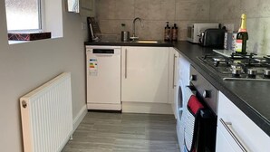 Une cuisine compacte équipée d’un lave-vaisselle, d’un four à micro-ondes, d’une cuisinière et d’une fenêtre donnant sur un paysage agréable.