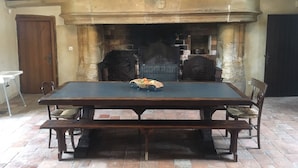 Ein Essbereich mit einem großen Holztisch, vier Stühlen und einem Kamin.