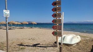 Une plage avec un panneau indiquant la présence d’installations telles que des douches, des toilettes et un terrain de rugby.