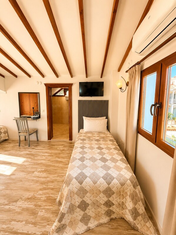 A bedroom with a bed, a TV, a chair, and a window with curtains. - Mai S'ema Otel Dalyan (Cesme)