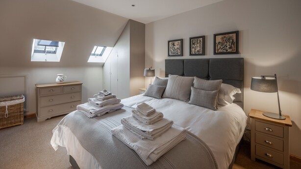 A bedroom with a bed, bedside tables, a lamp, and artwork on the wall. - Delightful highland home in Ballater village (Ballater)