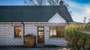 A small, single-story house with a sloped roof, a front porch, and a sign that reads "Fairfield Cottage." - Delightful highland home in Ballater village (Ballater)