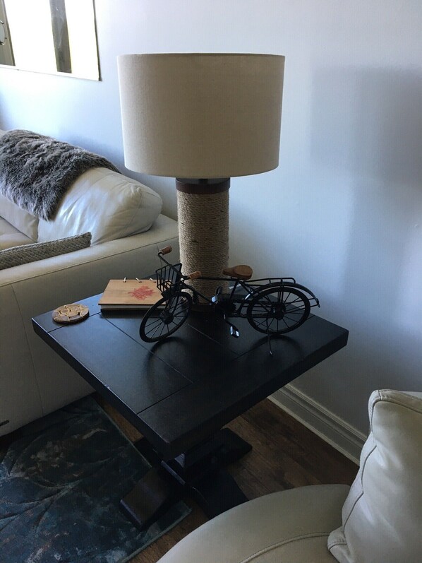 A room with a black table, a lamp, a small bicycle, and a cat tree. - Modern Muskoka Executive 2 Bedroom Condo/Loft. Minutes to the Provincial Parks! (Huntsville)