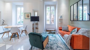 Un salon moderne comprenant un coin repas, un canapé et un téléviseur.
