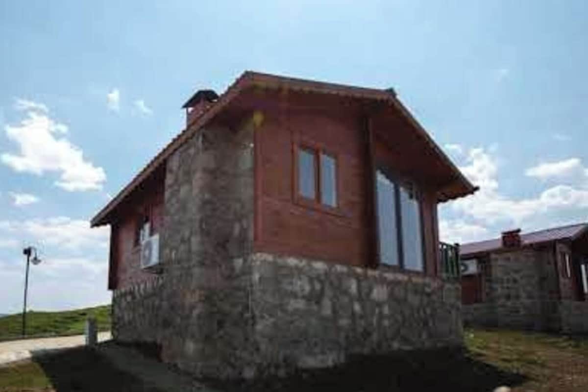 A single-story building with a sloped roof, a small porch, and a window.