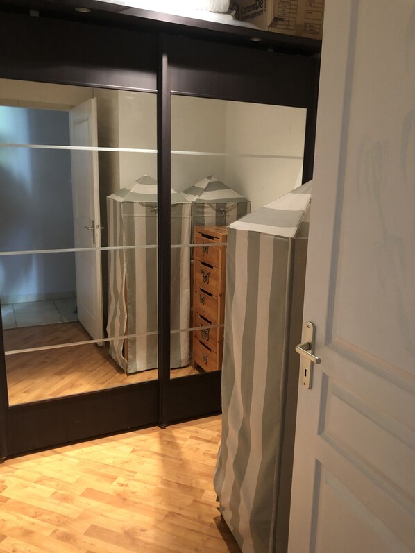 A room with a wooden floor, a wardrobe with mirrored doors, and a striped curtain. - Modern 4-bedroom villa, air conditioning in the living area, fabulous terrace/garden, large pool. (Port-Sainte-Foy-et-Ponchapt)