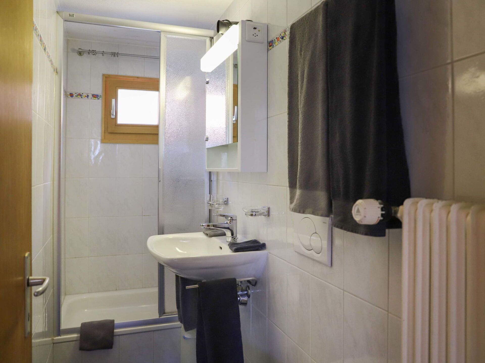 A bathroom with a white sink, a bathtub, and a shower.
