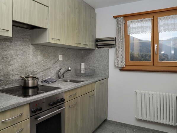 A modern kitchen with granite countertops, stainless steel appliances, and wooden cabinets.