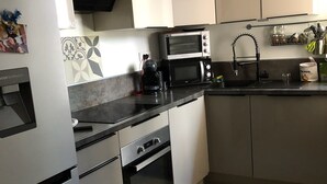 A modern kitchen with a built-in oven, microwave, and coffee maker. - 2-room apartment for 2 people close to Moure Rouge beach. (Cannes)
