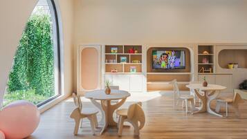 Un moderno cuarto de juegos para niños, con un amplio ventanal, muebles de madera y un televisor.
