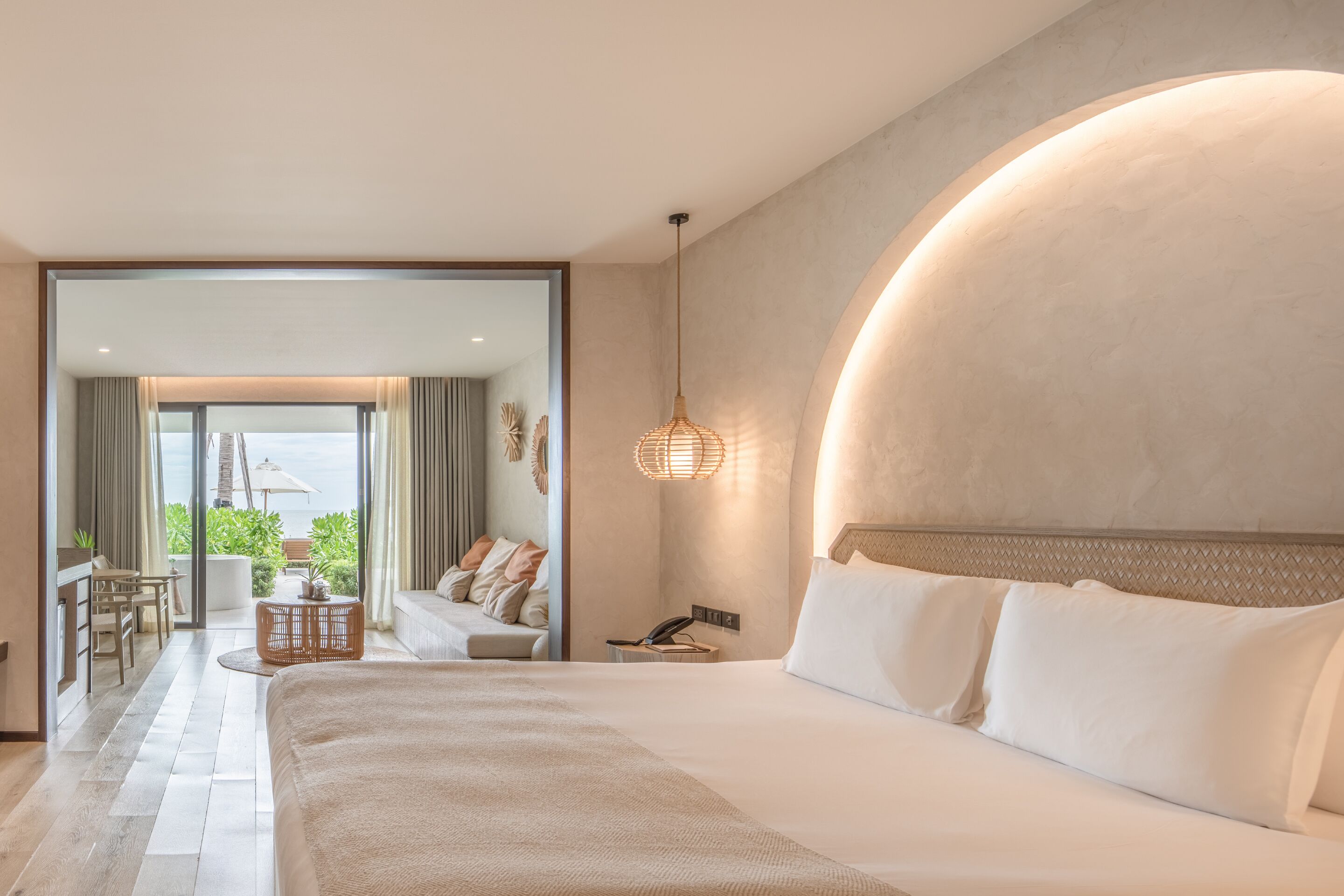 Une chambre d’hôtel moderne dotée d’un grand lit, d’un coin salon avec vue et d’un balcon.