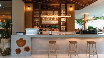 Una zona de bar con mostrador, taburetes y una máquina de café.