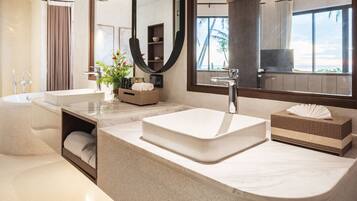 A modern bathroom with a large sink, a bathtub, and a mirror.