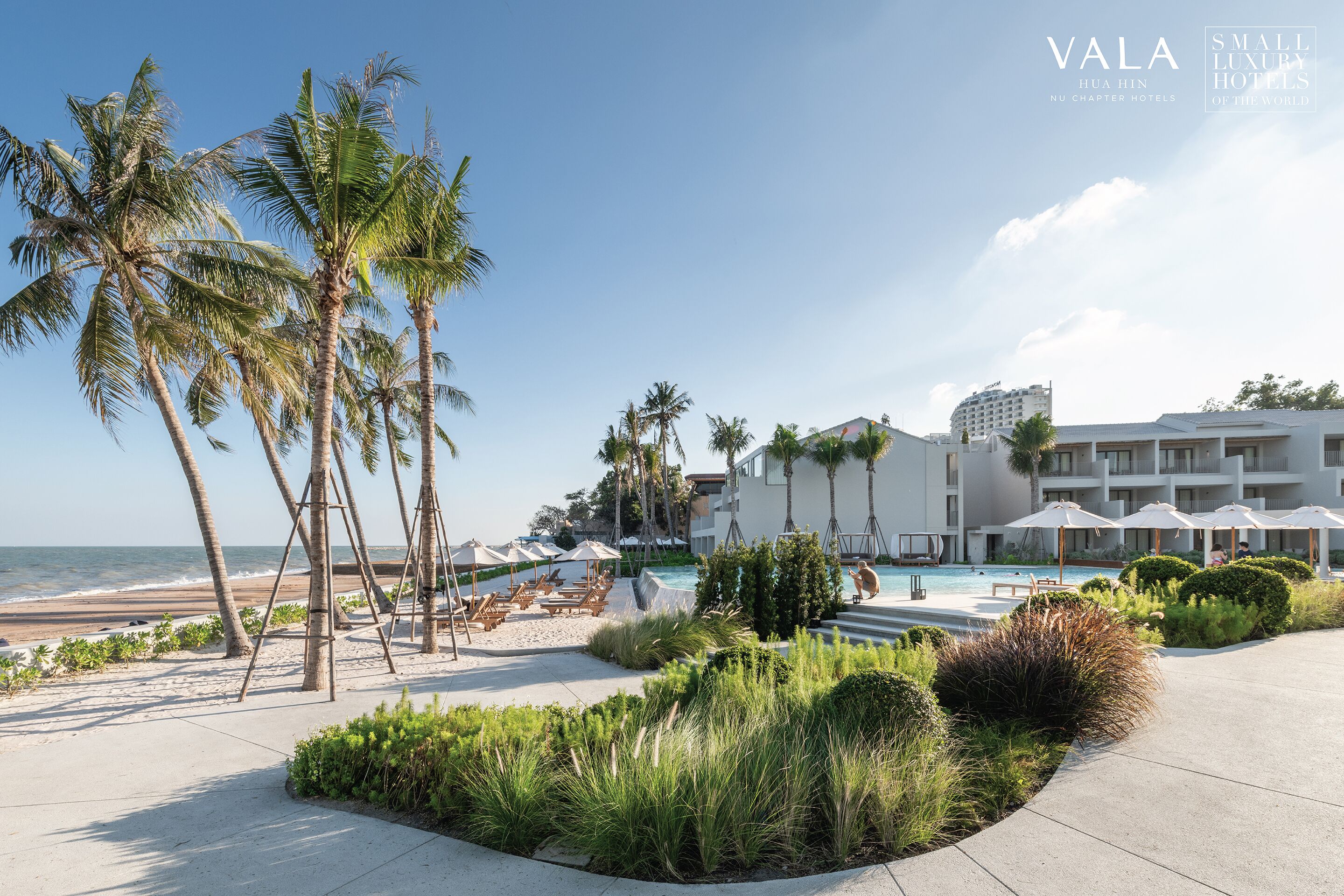 A resort with a pool, palm trees, and a beach.