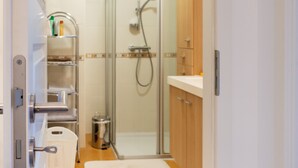 Une petite salle de bain comprenant une douche, des toilettes et un lavabo.