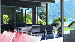An outdoor dining area with a view of mountains and a lake.