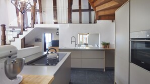 A modern kitchen with a built-in island, a large mixer, and a stove.