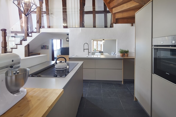 Una cocina moderna con una isla integrada, una batidora grande y una estufa.