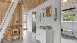 A modern bathroom with white cabinetry, a wooden bench, a sink with decorative bowls, and a window with a view of greenery. - Beautiful home in Aabenraa with WiFi (Aabenraa)