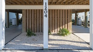 Un espacio al aire libre techado con un cerco de madera y un pilar blanco que muestra el número 1204.