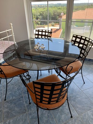 Enjoy meals in this dining area with a round table and four chairs, surrounded by a beautiful view of the green landscape.