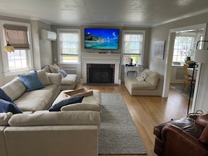 Enjoy a warm and inviting living space with a fireplace, comfortable seating, and a television.
