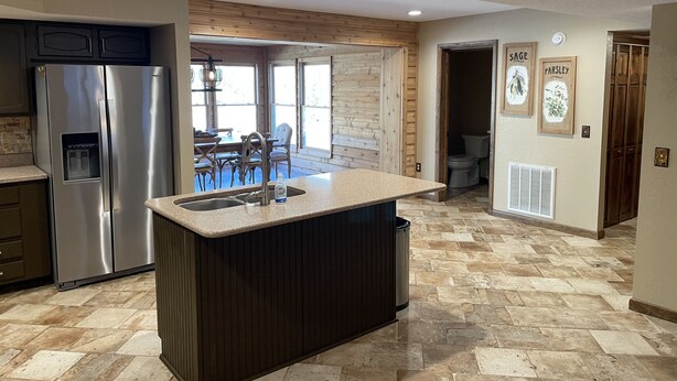 Una cocina moderna con una isla central, electrodomésticos de acero inoxidable y un comedor con vistas.