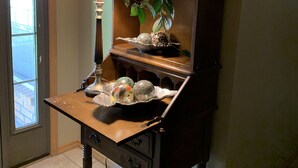 A wooden desk with a lamp, decorative items, and a potted plant. - No Worries (Spiro)