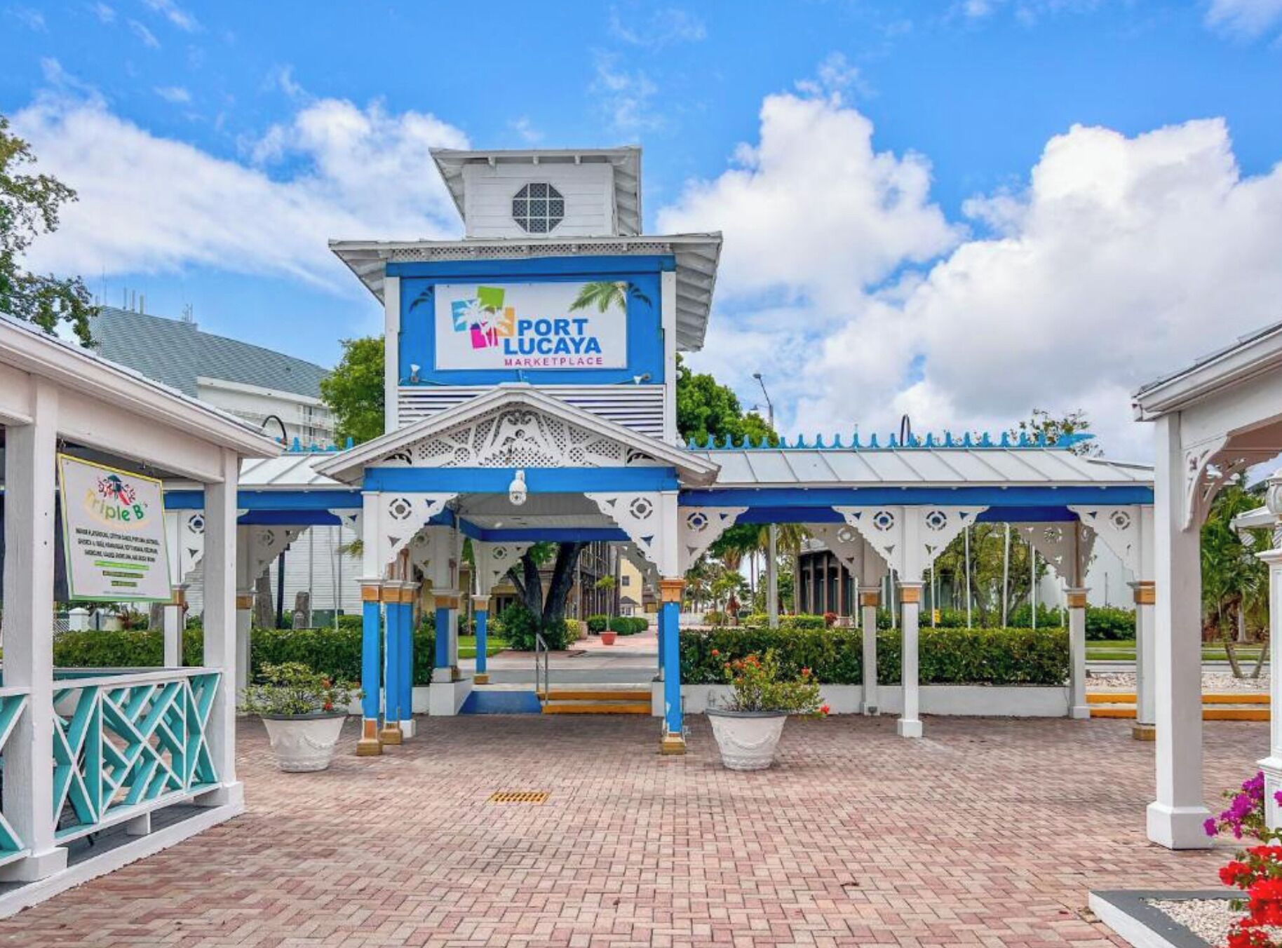 A covered entrance to Port Lucaya Marketplace with a blue and white color scheme and a central archway.