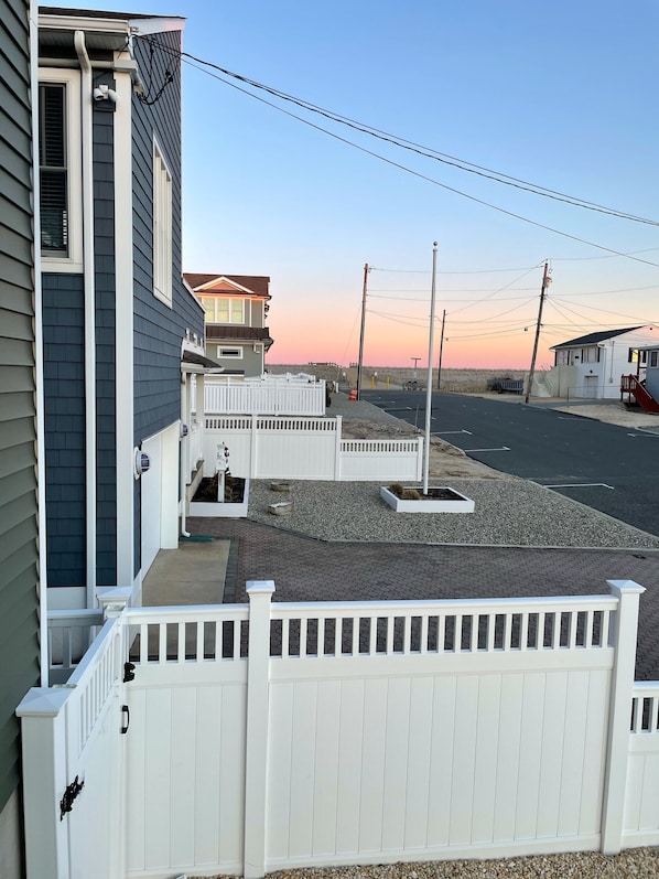 A residential area with houses, a gated driveway, and a clear sky.