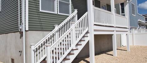 Une maison à deux étages dotée d’un porche et d’un escalier.