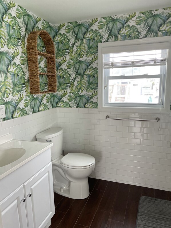 A bathroom with a toilet, a sink, and a window.
