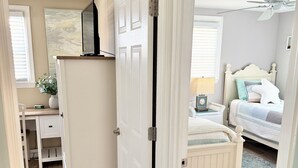 Een kamer met een bed, een bureau en een kledingkast.