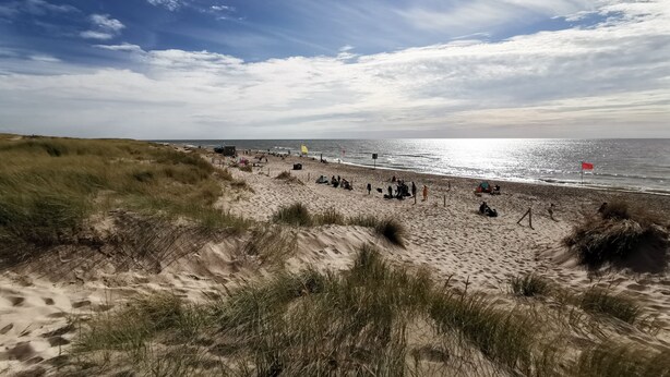 Une plage avec des dunes de sable et un ciel dégagé.