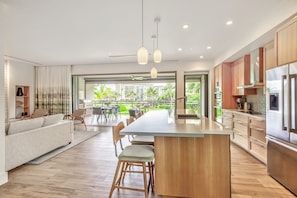 Une cuisine moderne dotée d’un îlot central, de meubles en bois et d’appareils électroménagers en acier inoxydable.