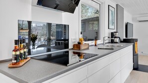 Una cocina moderna con una isla grande, horno empotrado y cafetera.
