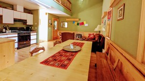 A spacious kitchen with a dining area, wooden furniture, and a staircase. - Big Mazama Cabin on 5 Acres: Huge Goat Wall Views (Mazama)