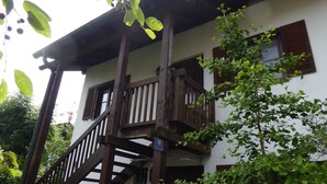 A two-story building with a wooden balcony and a sign indicating the number 19.